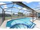Refreshing in-ground pool surrounded by a screened enclosure, a spa, and outdoor seating at 7764 Indian Ridge N Trl, Kissimmee, FL 34747