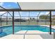 Sparkling in-ground pool with screened enclosure offers a relaxing outdoor experience at 7764 Indian Ridge N Trl, Kissimmee, FL 34747