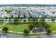 Aerial view of a residential neighborhood, showing homes, green spaces, and a lake in the background at 8290 Nemours Pkwy, Orlando, FL 32827