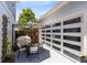 Back patio space with an outdoor dining set, grill, privacy fencing, and garage with glass door at 8290 Nemours Pkwy, Orlando, FL 32827