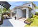Home's backyard showcasing a patio, garden, and a detached garage with transparent doors at 8290 Nemours Pkwy, Orlando, FL 32827