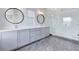 Elegant bathroom with double vanities, round mirrors, quartz counters and a modern glass-enclosed shower at 8290 Nemours Pkwy, Orlando, FL 32827