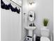 Charming bathroom with a pedestal sink, decorative shower curtain, and modern fixtures at 8290 Nemours Pkwy, Orlando, FL 32827