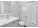 Bright bathroom features a tub-shower combo with sliding glass doors, a modern vanity, and a large framed mirror at 8290 Nemours Pkwy, Orlando, FL 32827