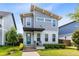 Charming two-story home featuring a blue front door, a covered entry, and well-maintained landscaping at 8290 Nemours Pkwy, Orlando, FL 32827
