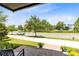 View from the porch showcases the street with mature landscaping and a view of neighborhood homes at 8290 Nemours Pkwy, Orlando, FL 32827