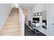 Bright home office space featuring a white desk and hardwood stairs leading to the upper level at 8290 Nemours Pkwy, Orlando, FL 32827
