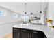 Open-concept kitchen boasts a granite island with modern pendant lighting and hardwood floors at 8290 Nemours Pkwy, Orlando, FL 32827