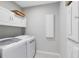 Efficient laundry room with modern washer and dryer, complemented by ample storage cabinets and a sleek design at 8290 Nemours Pkwy, Orlando, FL 32827