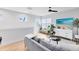Bright living room with hardwood floors, a comfortable gray sofa, and large windows at 8290 Nemours Pkwy, Orlando, FL 32827