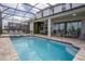 Spacious backyard featuring a refreshing pool, hot tub, covered patio, and lush greenery, perfect for outdoor living at 9071 Sunshine Ridge Loop, Kissimmee, FL 34747