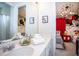 Bright bathroom vanity featuring dual sinks, modern fixtures, decor, and peek into themed bedroom at 9071 Sunshine Ridge Loop, Kissimmee, FL 34747