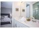 Bright bathroom featuring double sinks, white cabinets, and modern decor, adjoined to bedroom at 9071 Sunshine Ridge Loop, Kissimmee, FL 34747
