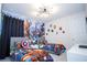 Vibrant bedroom featuring two twin beds with Avengers-themed decor and a unique light fixture at 9071 Sunshine Ridge Loop, Kissimmee, FL 34747