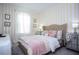 Charming bedroom with striped walls, soft pink accents, and elegant mirrored nightstands at 9071 Sunshine Ridge Loop, Kissimmee, FL 34747