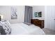 Cozy bedroom with a queen bed, TV, and modern dresser, perfect for relaxation at 9071 Sunshine Ridge Loop, Kissimmee, FL 34747