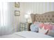 Bedroom featuring striped walls, soft pink accents, and elegant mirrored nightstand at 9071 Sunshine Ridge Loop, Kissimmee, FL 34747
