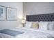 Serene bedroom featuring a queen bed with a tufted headboard and stylish wall decor at 9071 Sunshine Ridge Loop, Kissimmee, FL 34747