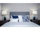 Bedroom with two bedside tables, decorative lamps, and a plush bed featuring a patterned headboard at 9071 Sunshine Ridge Loop, Kissimmee, FL 34747