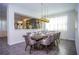 Formal dining room with a table set for dinner, accented by modern gold pendant lights at 9071 Sunshine Ridge Loop, Kissimmee, FL 34747