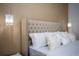 Close up on a luxurious bed with a tufted headboard, decorative pillows, and stylish pendant lights at 9071 Sunshine Ridge Loop, Kissimmee, FL 34747