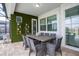 Covered patio with outdoor dining area featuring a unique green wall and stylish decor at 9071 Sunshine Ridge Loop, Kissimmee, FL 34747