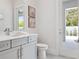 Bathroom with gray cabinets, white countertops, toilet, interior decor, and exterior views via a door at 9156 Sheen Sound St, Orlando, FL 32836
