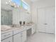 A bathroom featuring double sinks with vanity, shower, and marble flooring at 9156 Sheen Sound St, Orlando, FL 32836