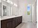 Bathroom features dual sinks, dark cabinets, white countertops, modern lighting and a tiled floor at 9156 Sheen Sound St, Orlando, FL 32836