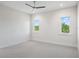 Empty bedroom with neutral carpet, two large windows, and neutral decor at 9156 Sheen Sound St, Orlando, FL 32836