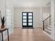 Elegant foyer features hardwood floors, modern chandelier, and a staircase with sleek railing at 9156 Sheen Sound St, Orlando, FL 32836