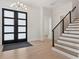 Bright entryway showcasing hardwood floors, staircase with iron railing, and stylish lighting fixture at 9156 Sheen Sound St, Orlando, FL 32836