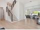 Inviting foyer with hardwood floors, modern staircase, and an open view to the living room at 9156 Sheen Sound St, Orlando, FL 32836