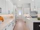 Clean kitchen featuring white cabinets, marble countertops, stainless steel appliances, and light wood flooring at 9156 Sheen Sound St, Orlando, FL 32836