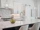 Close-up of kitchen island with marble countertops, modern cabinetry, and a sliding barn door visible in the background at 9156 Sheen Sound St, Orlando, FL 32836