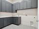 Laundry room with gray cabinets, white countertops, tile floors, washer and dryer hookups, and white walls at 9156 Sheen Sound St, Orlando, FL 32836