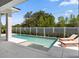 Back exterior featuring the pool with a sun shelf, two lounge chairs, patio and fenced yard at 9156 Sheen Sound St, Orlando, FL 32836