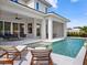 Back exterior view of the house, featuring the pool, patio, outdoor seating, and plenty of natural light at 9156 Sheen Sound St, Orlando, FL 32836