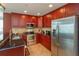 Kitchen with dark wood cabinets, stainless steel appliances, and granite countertops at 101 S Eola Dr # 1021, Orlando, FL 32801