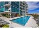 Stunning pool with lounge seating outside a condominium with glass balconies and tropical plants at 101 S Eola Dr # 1021, Orlando, FL 32801
