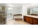 Bright bathroom with a garden tub under an arched window and a glass door shower at 10142 Serotina Ct, Orlando, FL 32832