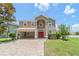 Charming two-story home with red door, beige exterior, manicured lawn and brick driveway at 10142 Serotina Ct, Orlando, FL 32832