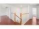 Hallway with wood floors and white railings leading to bedrooms at 10142 Serotina Ct, Orlando, FL 32832
