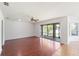 Bright living room with wood floors, ceiling fan, and glass sliding doors to the outside at 10142 Serotina Ct, Orlando, FL 32832