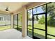 A view of the screened-in porch with ceiling fan, overlooking the manicured backyard with white fence and lush landscaping at 10142 Serotina Ct, Orlando, FL 32832