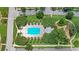 Overhead view of a community pool with ample seating, surrounded by mature trees and lush landscaping at 102 Hammock Preserve Loop, Winter Garden, FL 34787