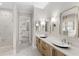 Bright bathroom featuring dual sinks, glass shower, and walk-in closet at 102 Hammock Preserve Loop, Winter Garden, FL 34787