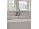 Close-up of tub fixtures, marble tile backsplash, and a window view at 102 Hammock Preserve Loop, Winter Garden, FL 34787