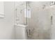 Modern bathroom shower featuring marble tile and a frameless glass enclosure at 102 Hammock Preserve Loop, Winter Garden, FL 34787