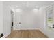 Bright, empty bedroom with hardwood floors, ceiling fan, and side door at 102 Hammock Preserve Loop, Winter Garden, FL 34787